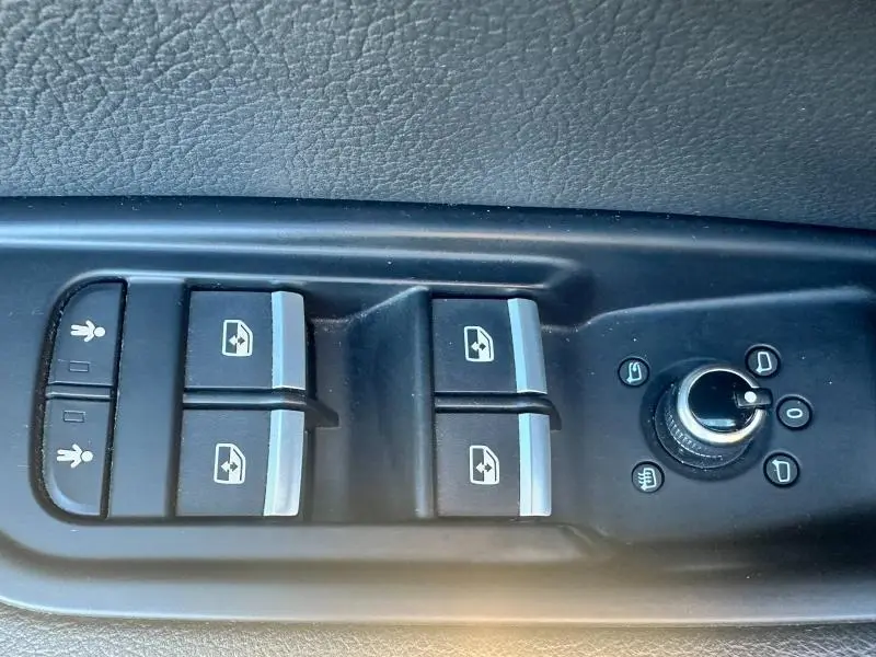 Gros plan sur les commandes des vitres électriques et rétroviseurs d'une Audi A5 Sportback 2018, intérieur noir.