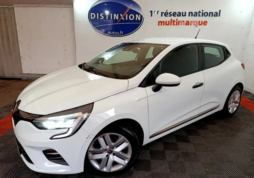 Renault Clio Business blanc vue 3/4 avant droit avec phares LED allumés dans un showroom intérieur.