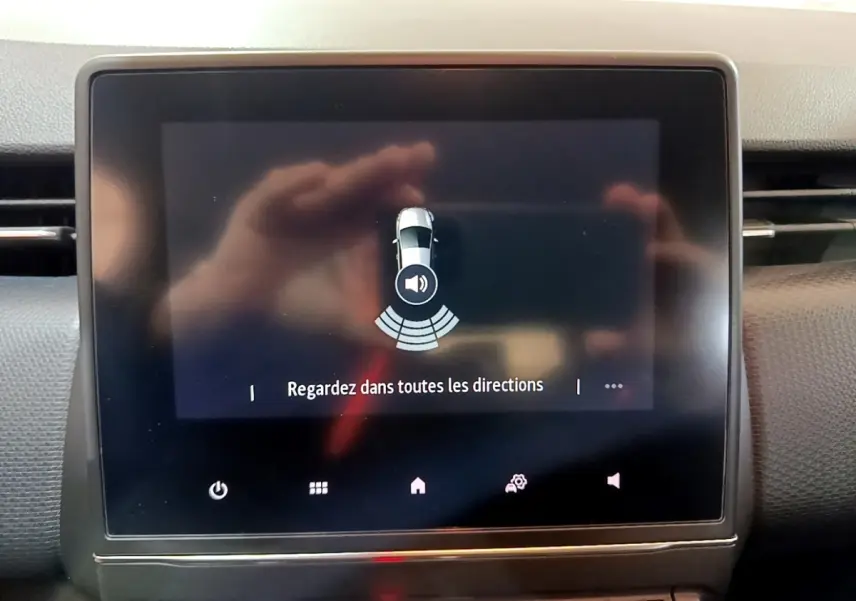 Écran tactile central de la Renault Clio Business blanc, affichant l'alerte de capteurs de proximité en vue intérieure.