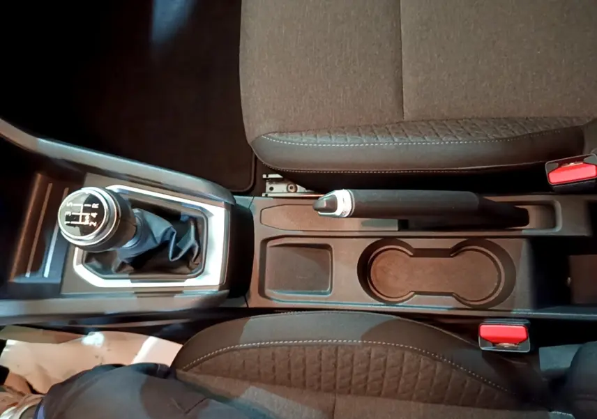 Vue plongeante sur la console centrale de la Renault Clio Business blanche, avec levier de vitesse manuel et frein à main.