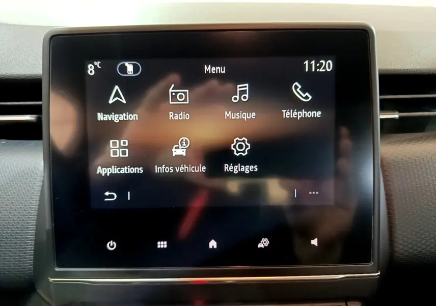 Écran tactile central de la Renault Clio Business blanc, affichant le menu principal avec navigation et réglages.