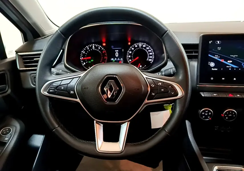 Vue intérieure centrée sur le volant cuir noir de la Renault Clio Business 2021 avec tableau de bord et écran tactile.