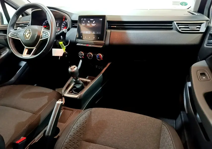 Vue intérieure avant de la Renault Clio Business 2021, tableau de bord noir avec écran tactile central et volant cuir multifonctions.