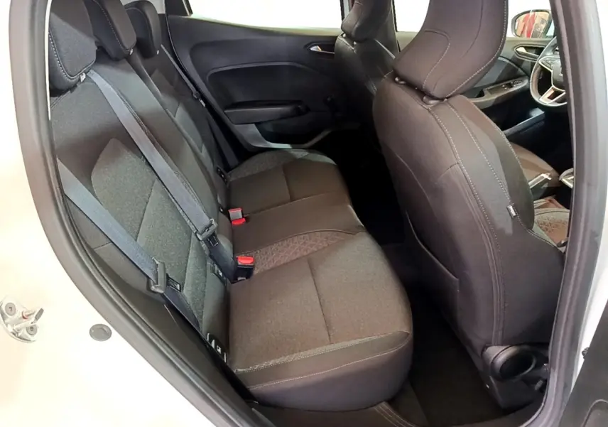 Vue intérieure côté arrière droit de la Renault Clio Business blanche, montrant les sièges arrière en tissu gris foncé.