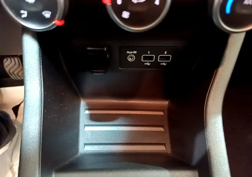 Gros plan sur la console centrale noire de la Renault Clio Business avec ports USB et entrée Aux-In sous les commandes de climatisation.