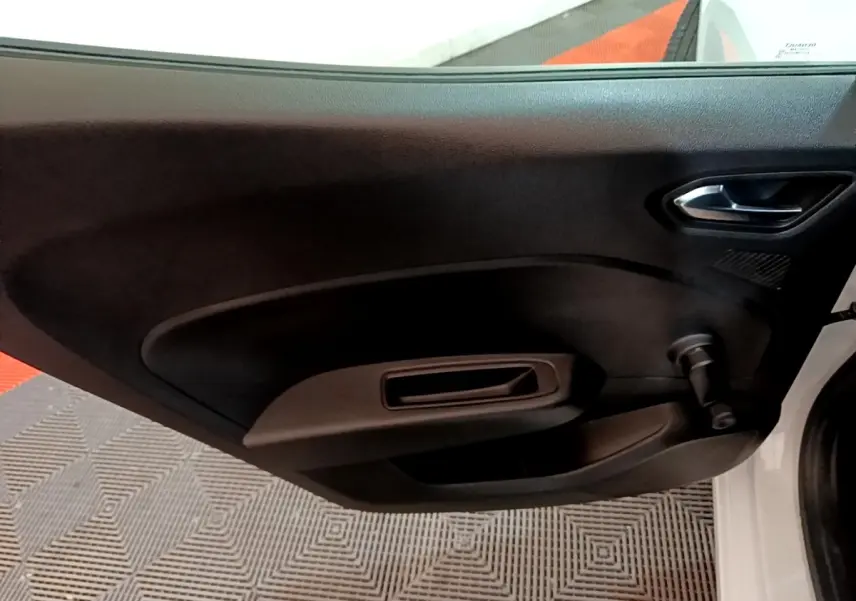 Vue intérieure de la porte avant droite blanche d'une Renault Clio Business SCe 65 avec poignée et manivelle de vitre.