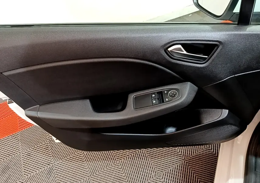Vue intérieure du panneau de porte avant gauche noir d'une Renault Clio Business blanche, avec commandes électriques des vitres et rétroviseurs.