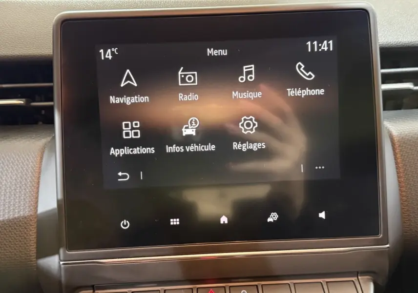 Écran tactile central de la Renault Clio Business blanc, affichant le menu principal avec options navigation et radio.
