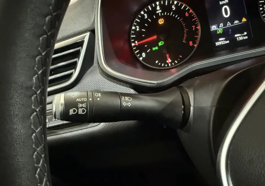 Gros plan sur le commodo d'éclairage et le tableau de bord numérique d'une Renault Clio Business blanche, 2020.