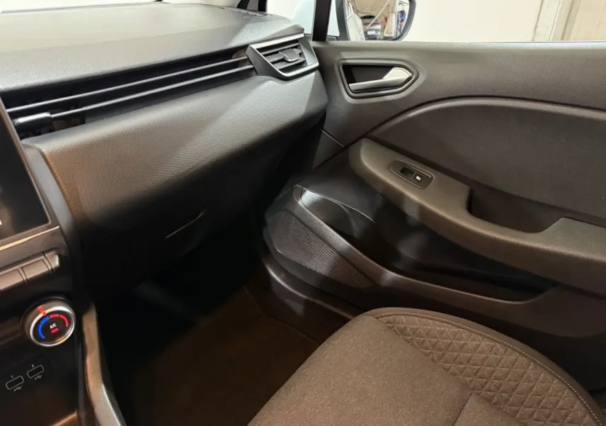 Intérieur côté passager de la Renault Clio Business 2020, avec tableau de bord noir et siège tissu gris.