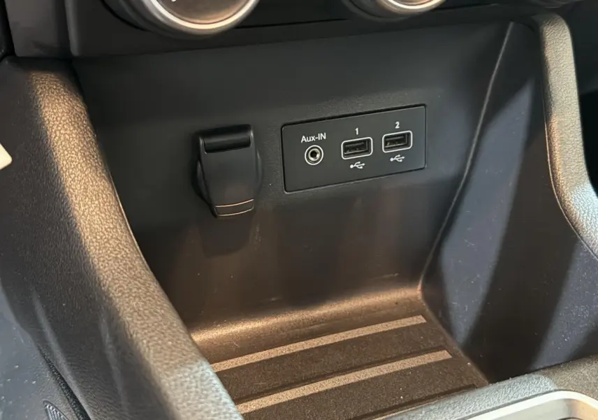 Gros plan sur la console centrale noire de la Renault Clio Business avec ports USB et prise Aux-In visibles.
