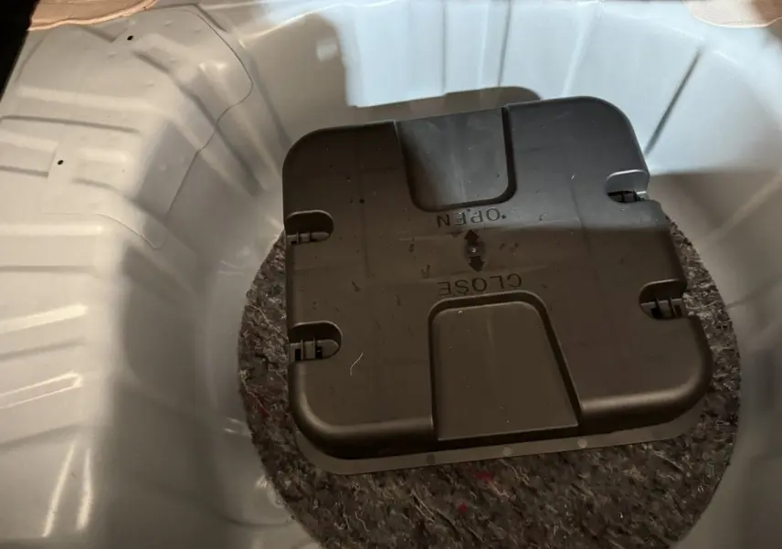 Gros plan sur le coffre blanc d’une Renault Clio 2020, montrant la roue de secours et son boîtier noir central.