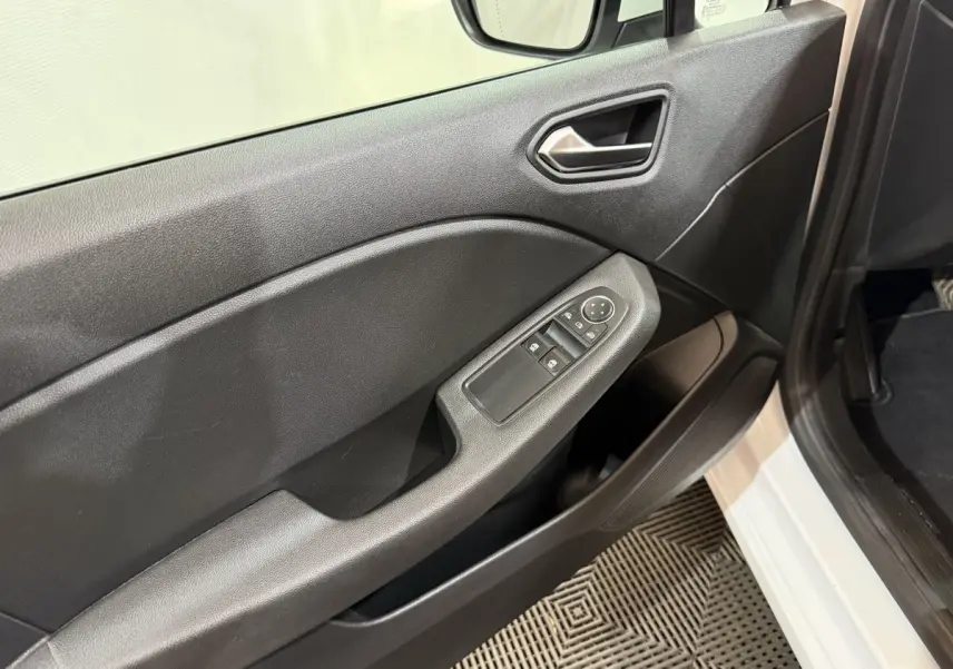 Intérieur côté conducteur de Renault Clio Business blanc, montrant la porte avec commandes des vitres et poignée noire.