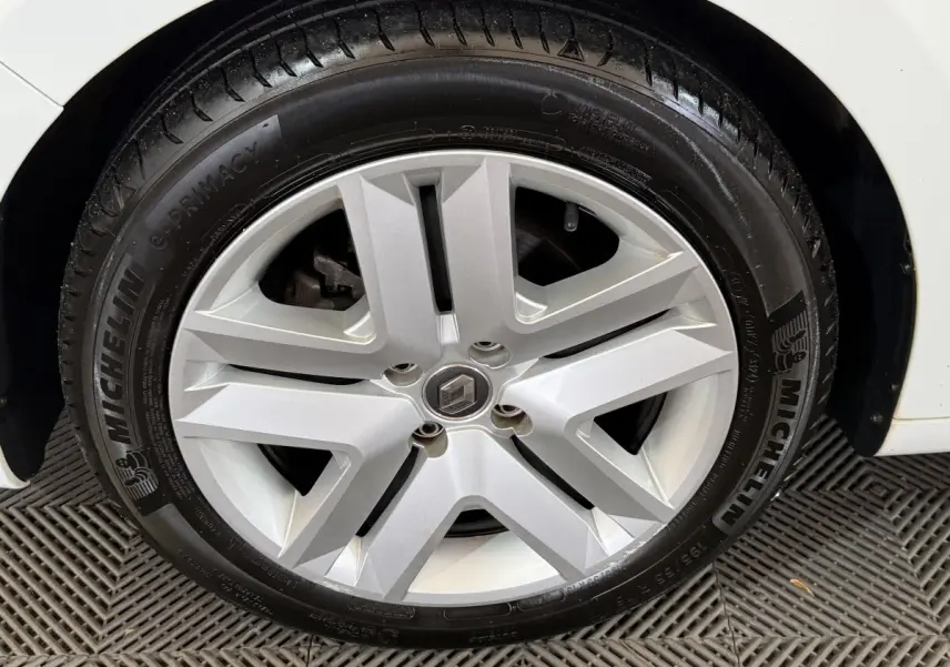 Vue rapprochée de la roue arrière droite d'une Renault Clio Business blanche, pneu Michelin visible.