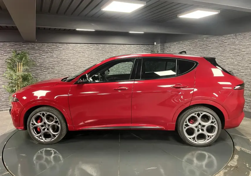 Alfa Romeo Tonale rouge vue de profil côté gauche, avec jantes alliage 20 pouces et étriers de frein rouges.