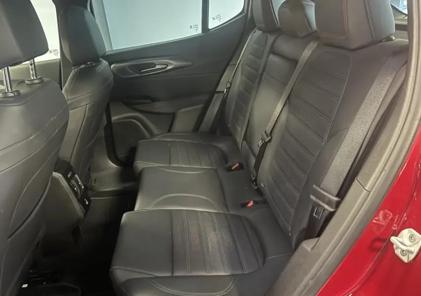 Vue intérieure côté droit des sièges arrière en cuir noir de l'Alfa Romeo Tonale rouge 2024, avec ceinture de sécurité visible.