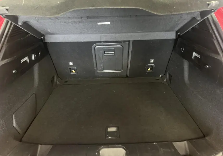 Coffre ouvert de l'Alfa Romeo Tonale rouge 2024, vue intérieure arrière montrant l'espace de chargement noir.