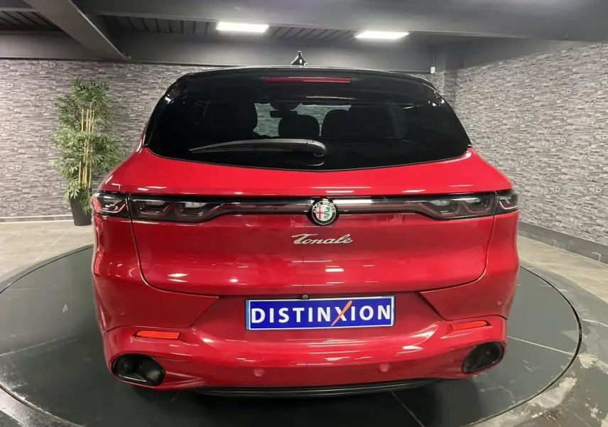 Vue arrière d'une Alfa Romeo Tonale rouge avec feux LED reliés et double sortie d'échappement noire.