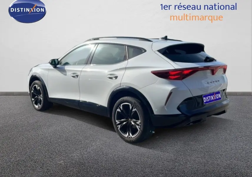 Vue 3/4 arrière droite du CUPRA Formentor blanc neige métal avec jantes noires et détails sportifs visibles.