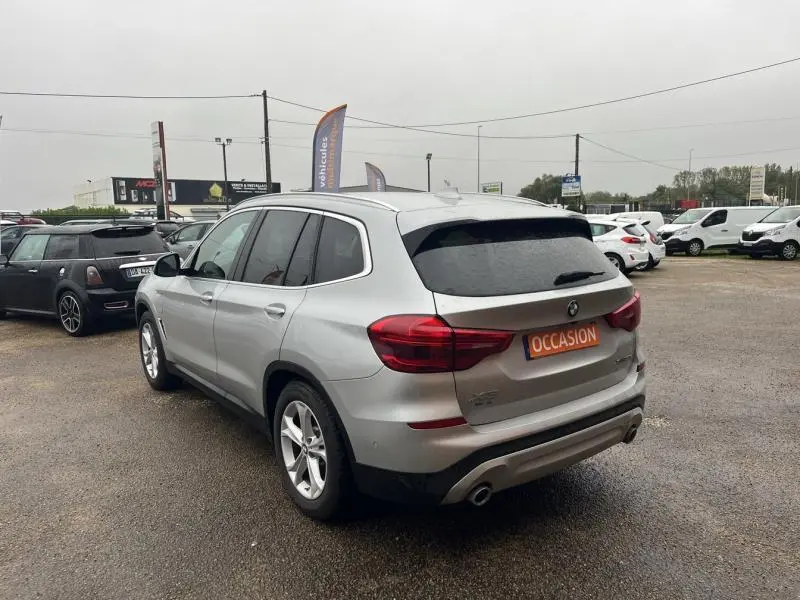 BMW X3 xDrive30e hybride rechargeable Glacier Silver vue 3/4 arrière droit sur parking avec plaque occasion