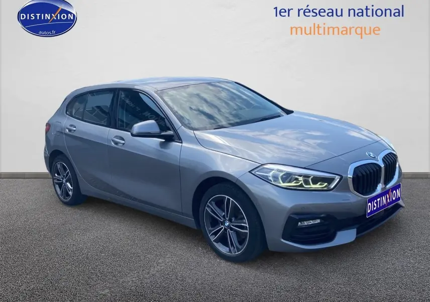 BMW Série 1 gris foncé vue 3/4 avant droit avec phares LED et jantes alliage 17 pouces double rayons.