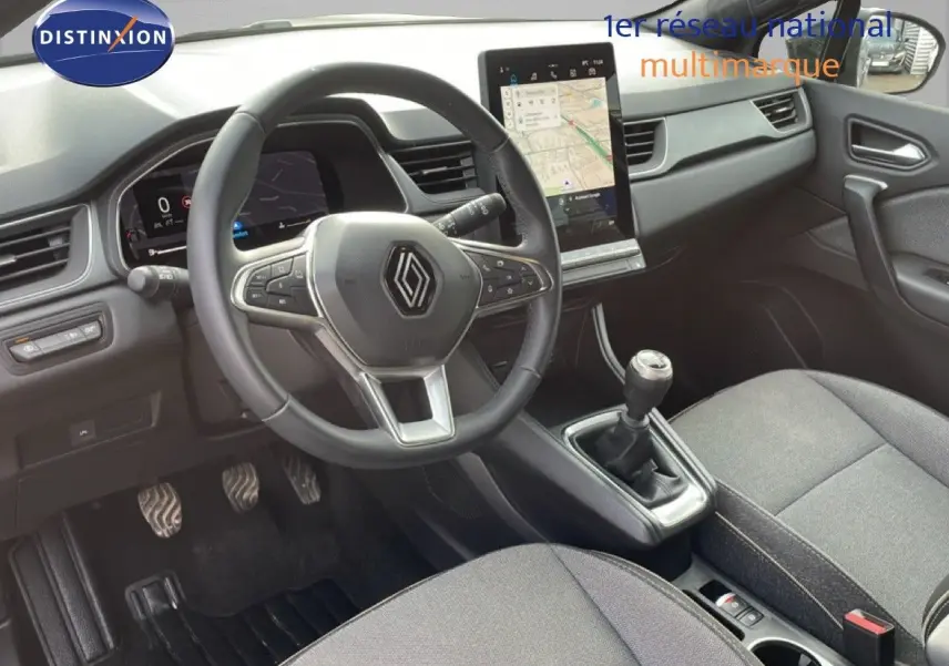 Vue intérieure avant du Renault Captur 2025 gris cassiopée, volant cuir multifonctions et écran tactile vertical.