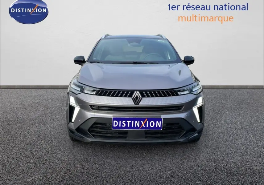 Vue de face du Renault Captur gris cassiopée métal avec toit noir, mettant en valeur ses feux LED distinctifs allumés.