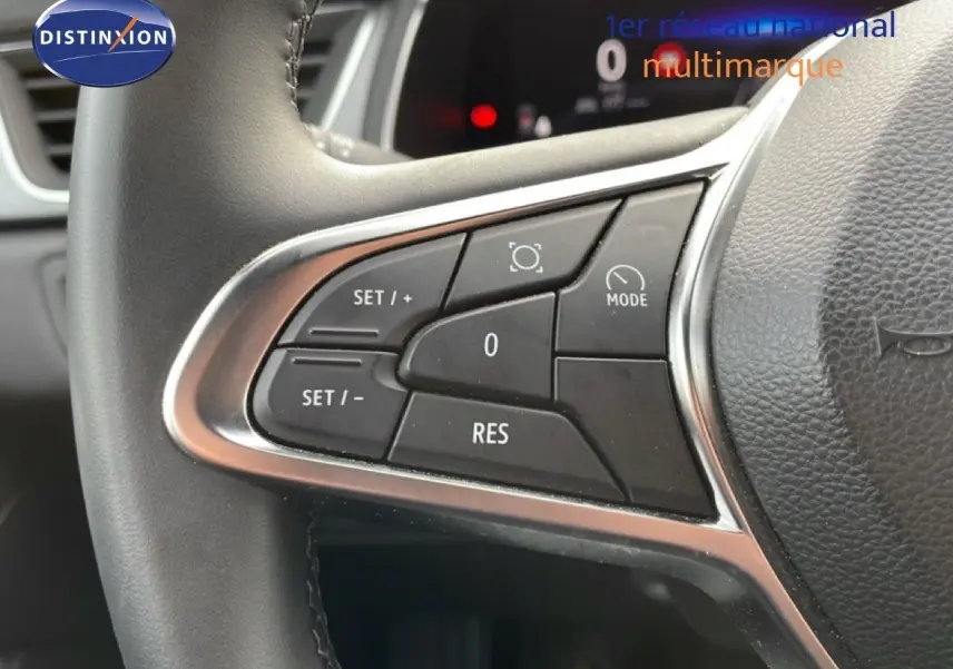 Gros plan sur les commandes au volant du Renault Captur 2025, finition gris Cassiopée métal avec toit noir.