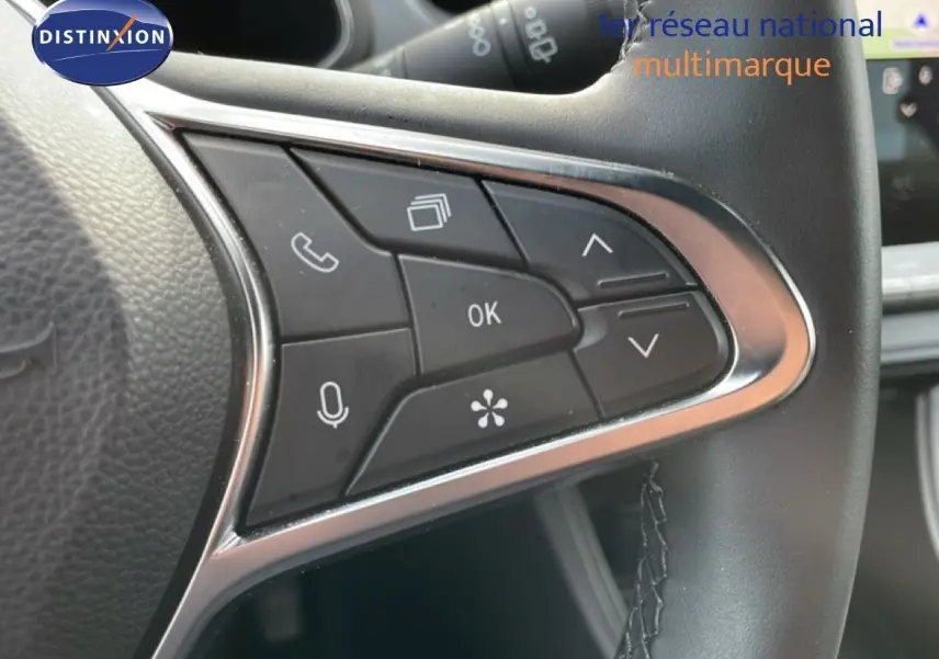 Gros plan sur les commandes multifonctions du volant noir du Renault Captur 2025, finition gris Cassiopée métal.