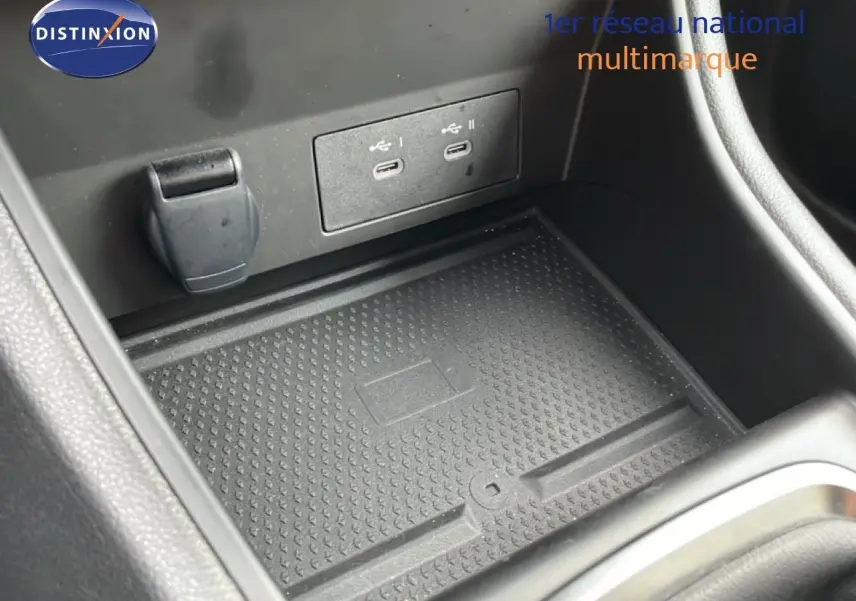 Gros plan sur la console centrale du Renault Captur gris Cassiopée, montrant les ports USB et un espace de rangement.
