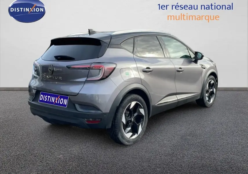 Vue 3/4 arrière droite d'un Renault Captur gris Cassiopée métal avec toit noir, jantes noires et vitres teintées.