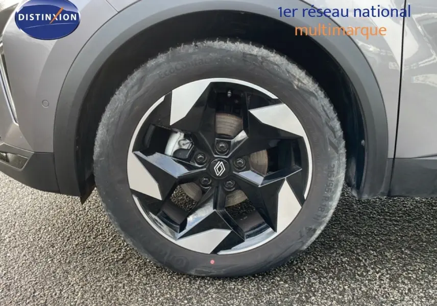 Gros plan sur la roue avant gauche du Renault Captur gris Cassiopée métal avec jante noire et argentée au design géométrique.