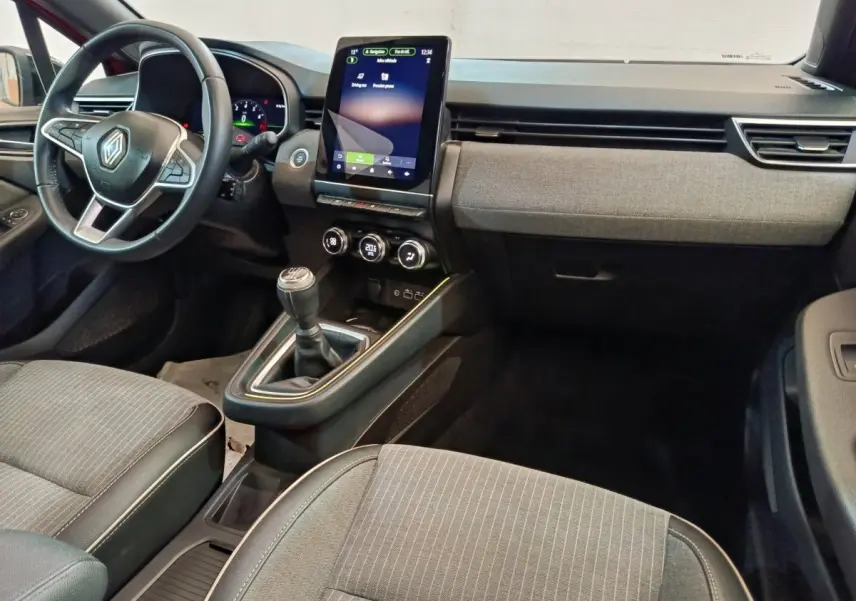 Vue intérieure avant de la Renault Clio Techno TCe 90 2024, tableau de bord avec écran tactile vertical et volant multifonctions.