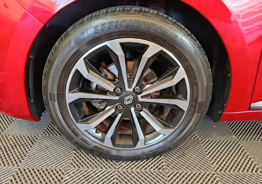 Gros plan sur la roue avant droite de la Renault Clio rouge 2024 avec jante alliage noire et grise au design moderne.