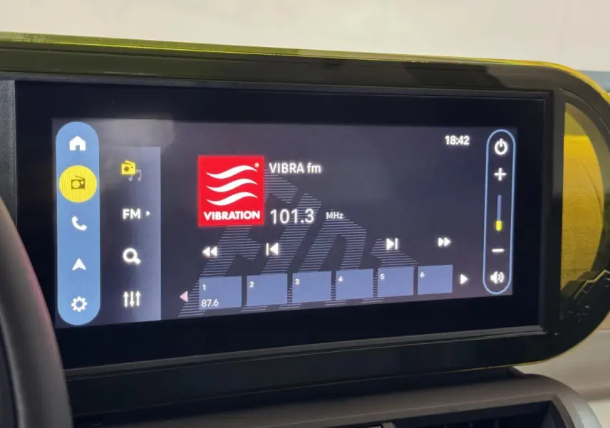 Écran tactile central de la Fiat Grande Panda marron affichant la radio FM à 101,3 MHz en intérieur.