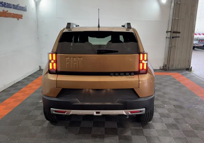 Vue arrière de la FIAT Grande Panda marron 2025 avec feux LED allumés et barres de toit visibles.