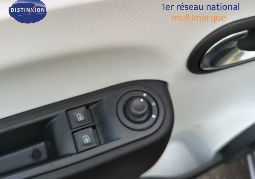 Gros plan sur les commandes de lève-vitres et réglage des rétroviseurs côté gauche d’une Renault Twingo gris acier.
