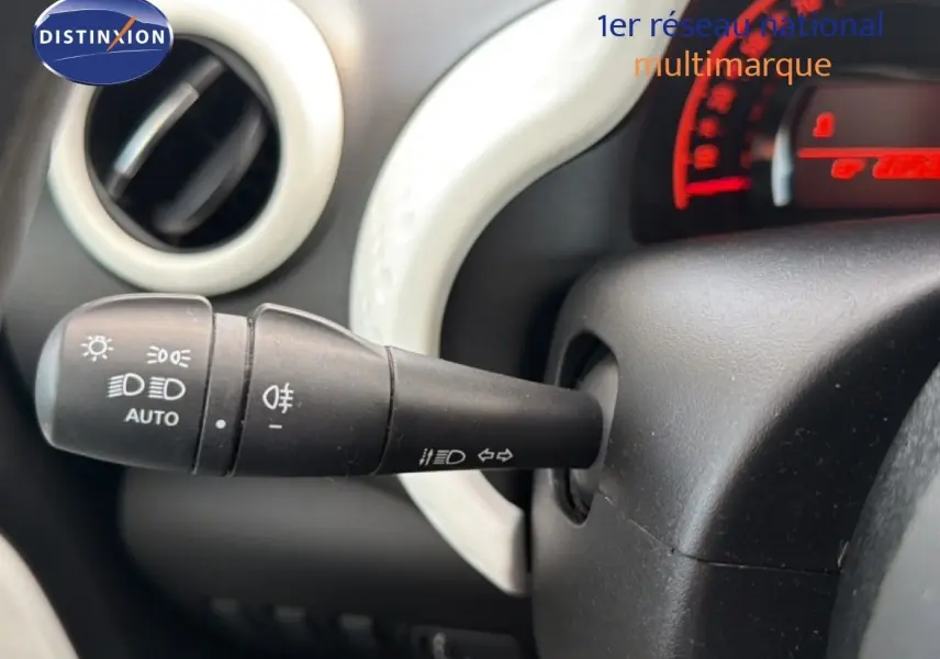 Gros plan sur la manette de commande des phares et clignotants dans l'habitacle d'une Renault Twingo gris acier.