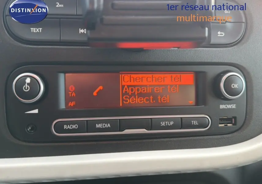 Détail de l'autoradio avec écran orange affichant les options de connexion téléphone dans une Renault Twingo gris acier.