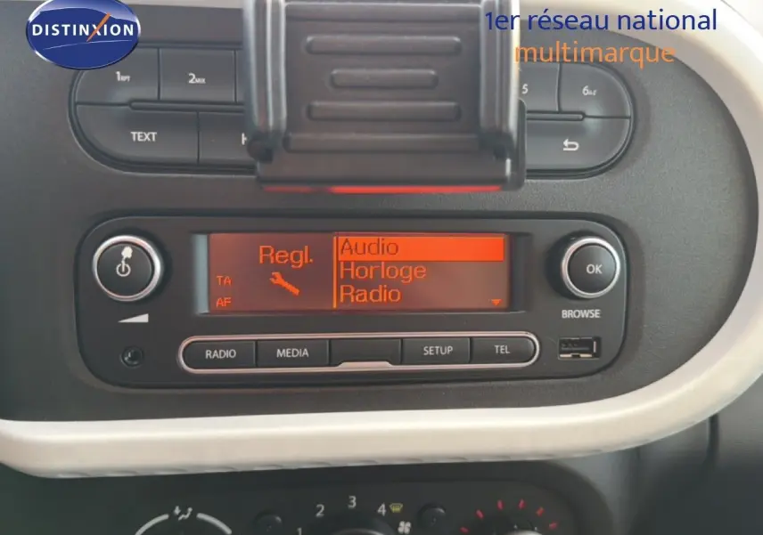 Gros plan sur la console centrale de la Renault Twingo gris acier 2021, affichant l’écran radio et les commandes audio.