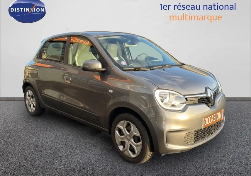 Renault Twingo gris acier vue 3/4 avant droit, compacte cinq portes avec phares arrondis et jantes spécifiques.