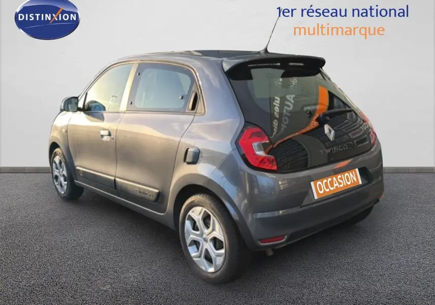 Vue 3/4 arrière droite d'une Renault Twingo gris acier 2021, compacte avec feux LED et cinq portes visibles.