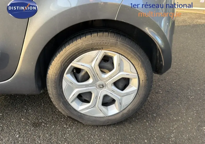 Gros plan sur la roue arrière droite d'une Renault Twingo gris acier, mettant en valeur la jante au design moderne.