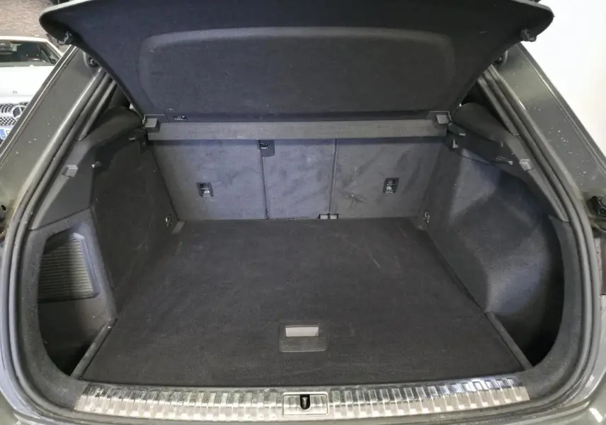 Coffre ouvert d’un Audi Q3 gris, vue arrière montrant l’espace de chargement et la finition intérieure noire.