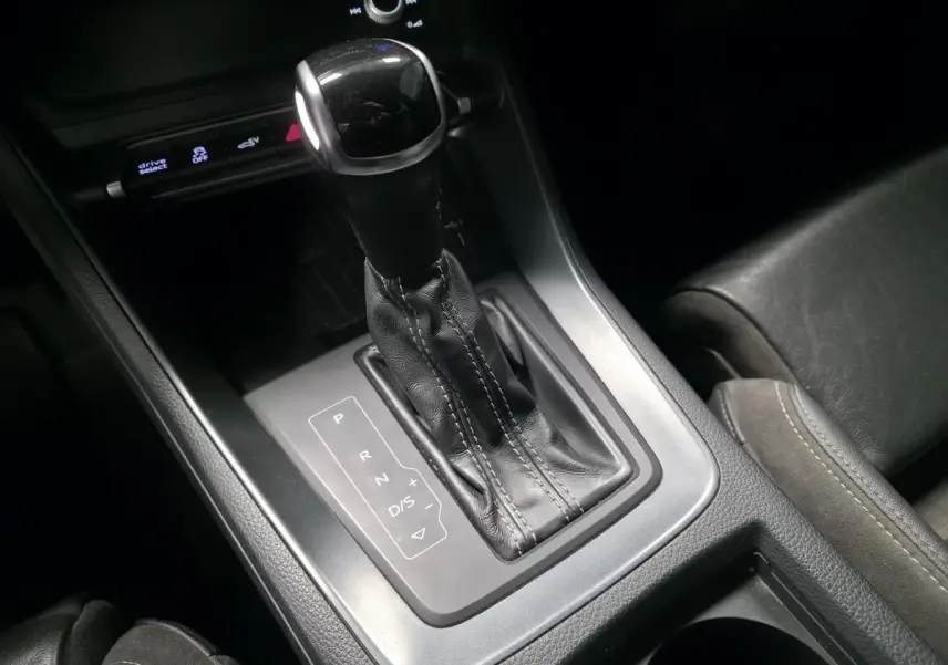 Gros plan sur le levier de vitesse automatique noir et argenté de l'Audi Q3 S Line 2021, intérieur cuir noir.