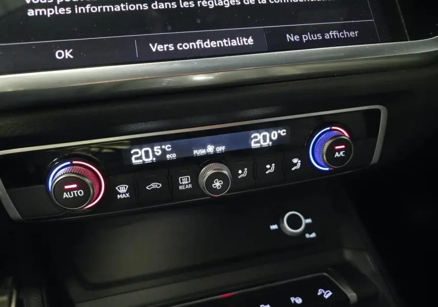 Détail de la console centrale de l’Audi Q3 S Line 2021 montrant la climatisation automatique bi-zone avec réglages numériques.
