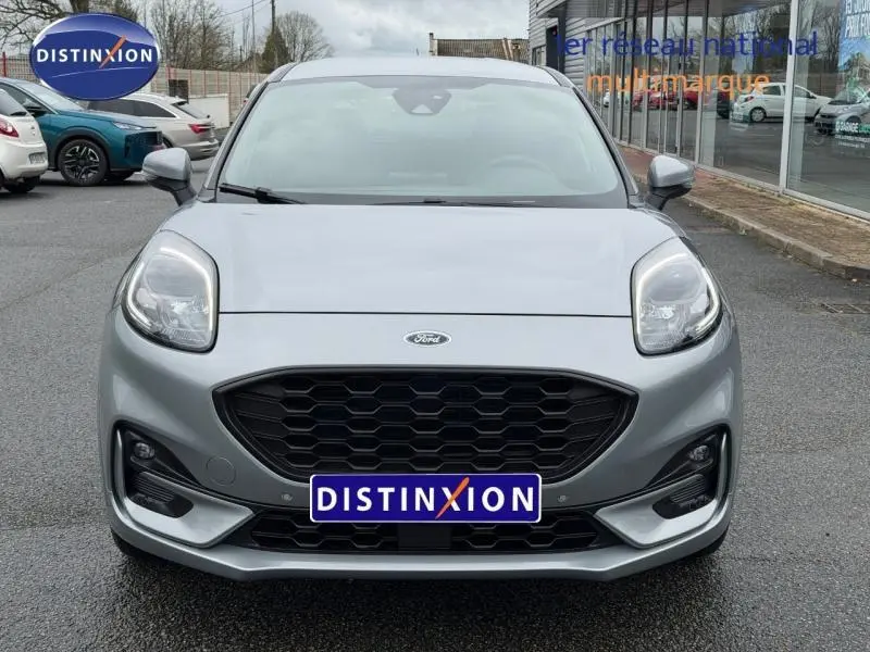 Vue frontale d'une Ford Puma 1.0 EcoBoost 155ch mHEV ST-Line gris Solar métallisé avec calandre noire et phares LED.
