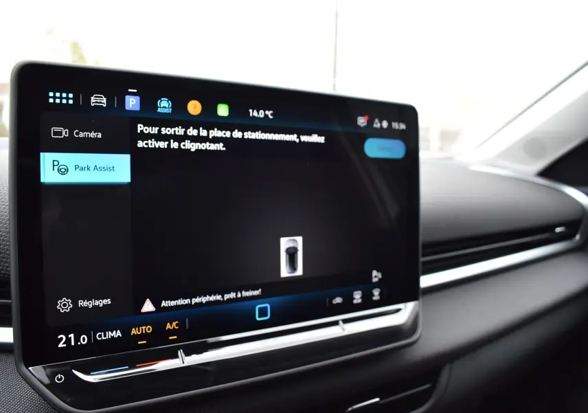 Écran tactile central du Volkswagen T-Roc 2025 affichant l'assistance au stationnement, intérieur noir.