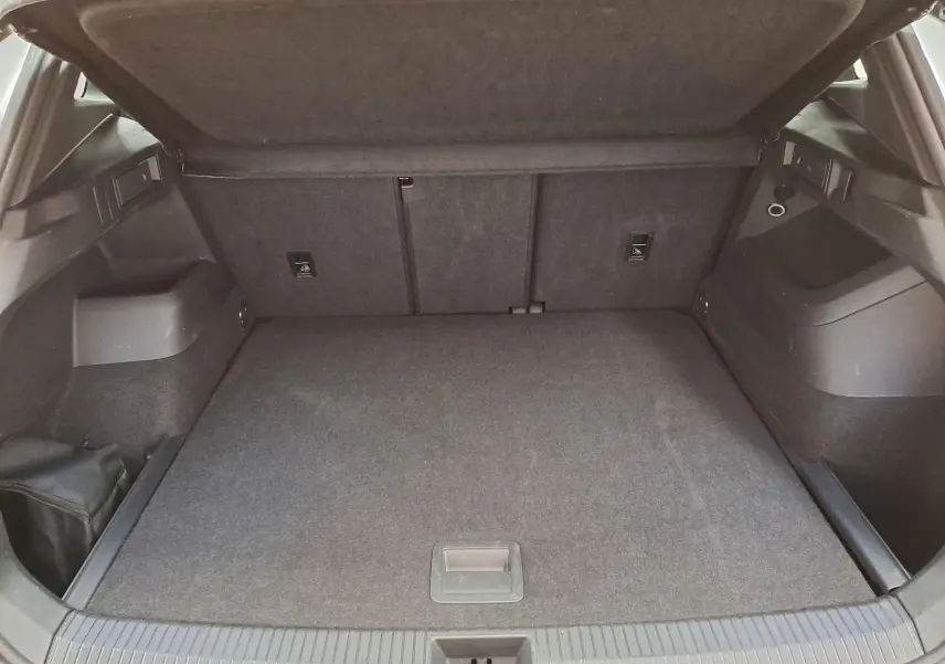 Coffre ouvert en vue arrière du Volkswagen Tiguan 1.5 eTSI blanc, montrant un espace de chargement propre et spacieux.