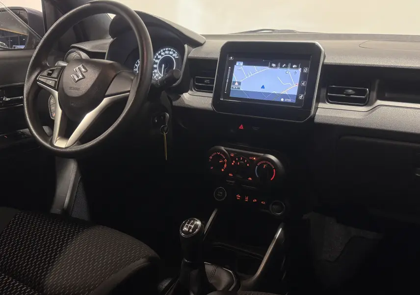 Vue intérieure de face du tableau de bord de la Suzuki Ignis 2022, avec écran tactile et levier de vitesse manuel.